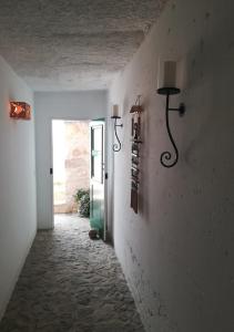 a hallway with a door and a lamp on a wall at Nos Kasa Povoaçao Velha in Cabeçadas