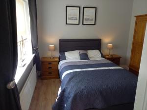 a bedroom with a bed with two night stands and two lamps at Sea Crest B&B Rossnowlagh in Rossnowlagh