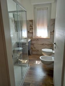 a bathroom with two toilets and a glass shower at B&B La Vela in Villa Rosa