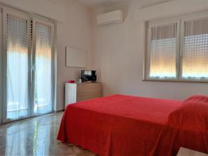 a bedroom with a red bed and a television at B&B La Vela in Villa Rosa