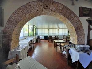 a restaurant with tables and chairs and a stone archway at B&B La Vela in Villa Rosa