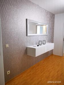 baño con lavabo y espejo en la pared en Milonia 3, en Bernkastel-Kues