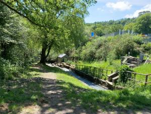 um caminho com uma cerca ao lado de um pequeno riacho em Old Co Op House -Forest of Dean em Bream