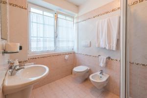 a bathroom with a sink and a toilet and a shower at Agritur Casamela in Taio