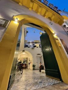 an archway in a building with a green door at Donna Grazia Relais in Gallipoli