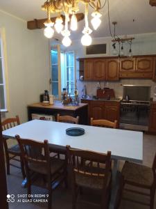 a kitchen with a large white table and chairs at Bike Civico 17 AFFITTA CAMERE in Venzone