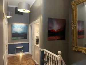 a hallway with two paintings on the wall and a mirror at Ben Cruachan Guest House in Edinburgh