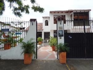 a white house with a black gate and potted plants at 5E Hotel Boutique in Girardot