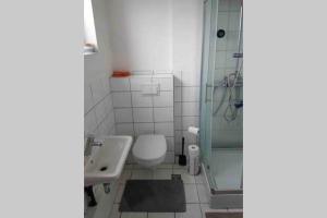 a bathroom with a toilet and a sink and a shower at Private studio apartment near the airport in Ytri-Njarðvík