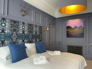 a bedroom with a large white bed with blue pillows at Ben Cruachan Guest House in Edinburgh