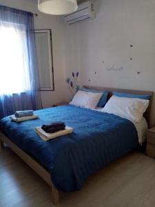 una camera con un letto blu e due vassoi sopra di AFFITTACAMERE AQVA FONTIS a Campello sul Clitunno