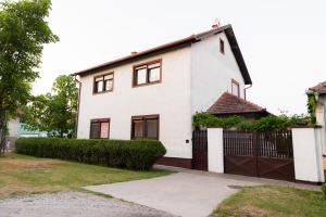 a white house with a black fence at Lausev Garden in Subotica