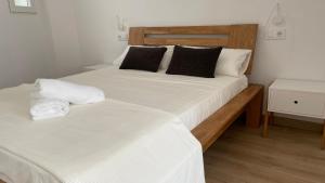 a bedroom with a bed with white sheets and black pillows at Mi Villa Apartamentos Dénia Centro in Denia