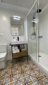 a bathroom with a shower and a sink and a toilet at Mi Villa Apartamentos Dénia Centro in Denia