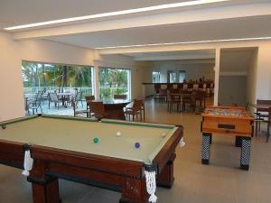 a pool table in a room with tables and chairs at Hotel Abrolhos in Nova Viçosa