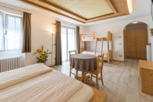 a bedroom with a bed and a desk and a bunk bed at Agritur Casamela in Taio