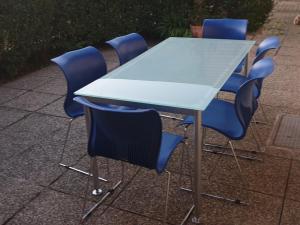 stół z czterema niebieskimi krzesłami wokół niego w obiekcie Ferienwohnung Donauauen w mieście Orth an der Donau