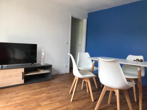 sala de estar con mesa y sillas blancas en Résidence le Manoir du Mont Canisy Piscine & Tennis, en Deauville