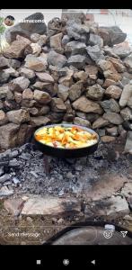 a pan of food sitting on top of a stone wall at Prenociste B&M - Lukomir in Lukomir