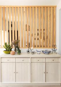 una cucina con armadietti bianchi e una parete in legno di Villa Berlenga ad Atouguia da Baleia