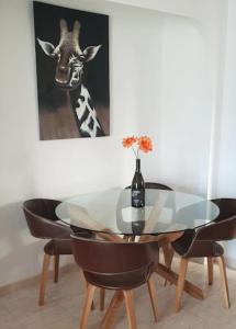 a dining room with a glass table and a giraffe at Inviting 2-Bed Apartment 5 minutes to the beach in Punta Prima