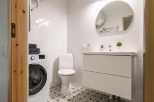 a white bathroom with a sink and a washing machine at Freshly renovated family apartment in Kuressaare +12 photos