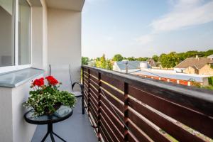 un balcón con una mesa y un jarrón de flores en Freshly renovated family apartment, en Kuressaare