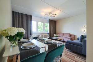 a living room with a table and chairs and a couch at Freshly renovated family apartment in Kuressaare
