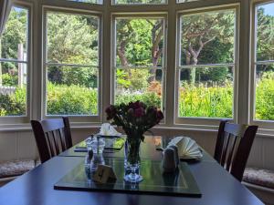 a dining room with a table with flowers in a vase at The Denes in Lynton