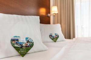 2 almohadas con corazones en una cama en una habitación de hotel en Hotel Kammerlander, en Neukirchen am Großvenediger