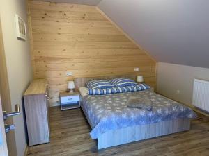 シュチルクにあるWilla RAJBIの木製の壁のベッドルーム1室(ベッド1台付)