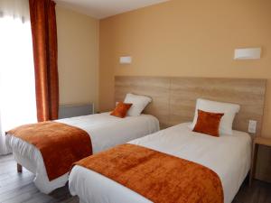 a hotel room with two beds and a window at Hotel Marinet in Châtillon-en-Michaille