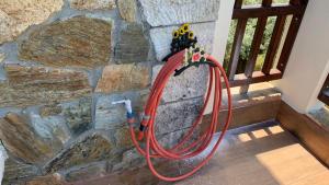 a red hose is attached to a stone wall at Thea Thalassa in Vourvourou