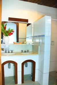 uma casa de banho com 2 lavatórios e um espelho em Pousada do Cais em Paraty