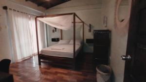 ein Schlafzimmer mit einem Himmelbett in einem Zimmer in der Unterkunft Sapa Inka in Montañita