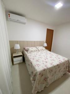 a white bedroom with a bed with a pink blanket at Residencial Ykutiba in Imbassai