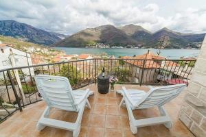 two chairs sitting on a balcony with a view of the water at Villa Angel in Kamenari