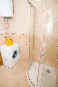 een badkamer met een douche en een wasmachine bij Villa Angel in Kamenari