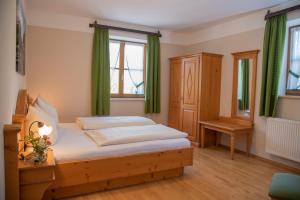 a bedroom with a bed and a window and green curtains at Hotel & Pension "Zum Birnthaler" in Kallmünz