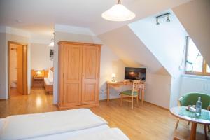 a bedroom with a bed and a desk in a room at Hotel & Pension "Zum Birnthaler" in Kallmünz