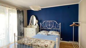 una camera da letto con una parete blu e un letto di Sunrise Apartamenty a Łeba