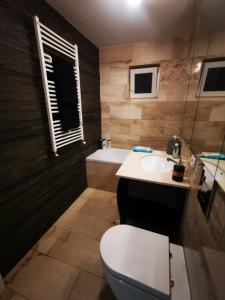 a bathroom with a toilet and a sink and a tub at Luxury apartment. 10 minutes taxi ride to center in Timişoara