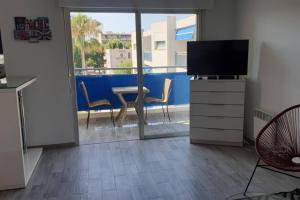 a living room with a television and a table and chairs at AiguesMarines in Cagnes-sur-Mer