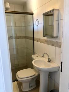 Un baño con inodoro, lavabo y espejo. en Casa aconchegante com piscina em Tiradentes, en Tiradentes