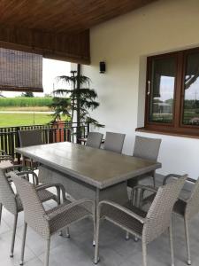 Une table à manger et des chaises sont disponibles sur la terrasse. dans l'établissement Chata u Rodaka, à Snochowice