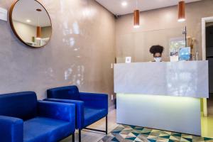 a woman in a waiting room wearing a face mask at Injoy Suítes & Aparts in Rio de Janeiro