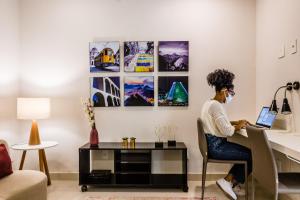 una donna seduta a una scrivania con un portatile di Injoy Suítes & Aparts a Rio de Janeiro
