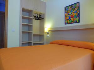 a bedroom with a bed with an orange bedspread at Rentalmar Diplomatic Park in Salou