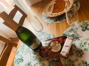 una botella de vino y una caja de fresas sobre una mesa en CASA la PAU, en Vilassar de Mar