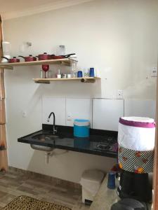 a kitchen with a black counter and a sink at Pousada O Mineiro - frente a praia in Galinhos